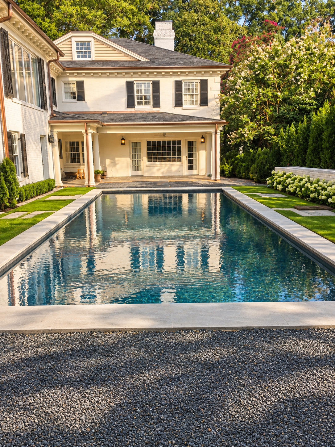 Outdoor living room with a pool, stonework, and covered seating
