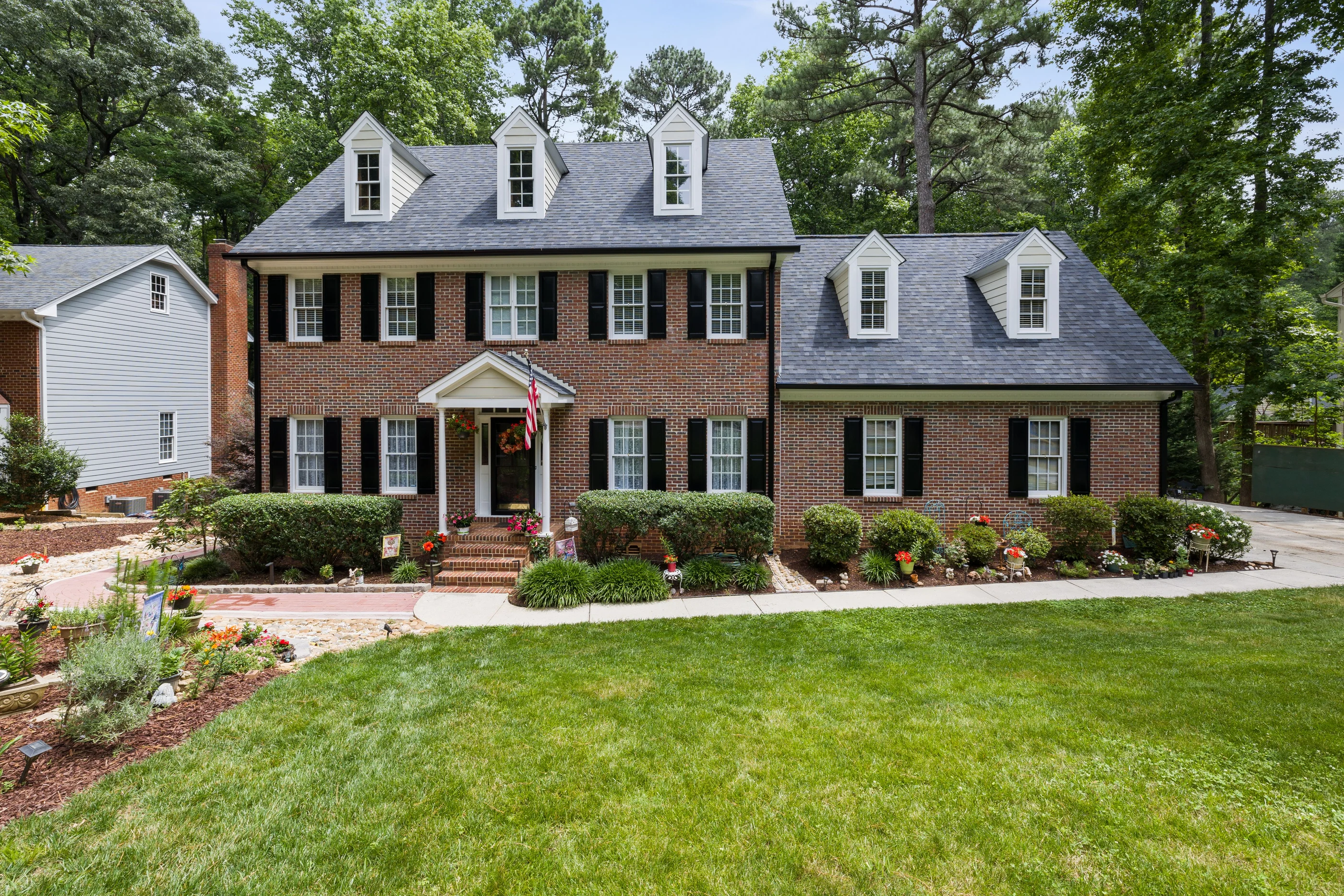 White luxury residence with broad lawn and symmetrical gables